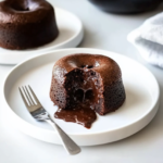 Fondant au chocolat avec cœur coulant servi sur une assiette blanche.