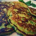 Blinis de courgette maison dorés et moelleux, cuits à la poêle, servis en gros plan pour une recette légère et savoureuse