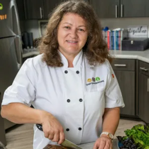 Cheffe professionnelle coupant des légumes frais dans une cuisine moderne