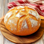 Pain maison croustillant avec croûte dorée et entailles sur planche en bois