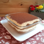 Tiramisu au Chocolat maison dans un plat en verre avec couches de crème mascarpone et biscuits, recouvert de cacao en poudre
