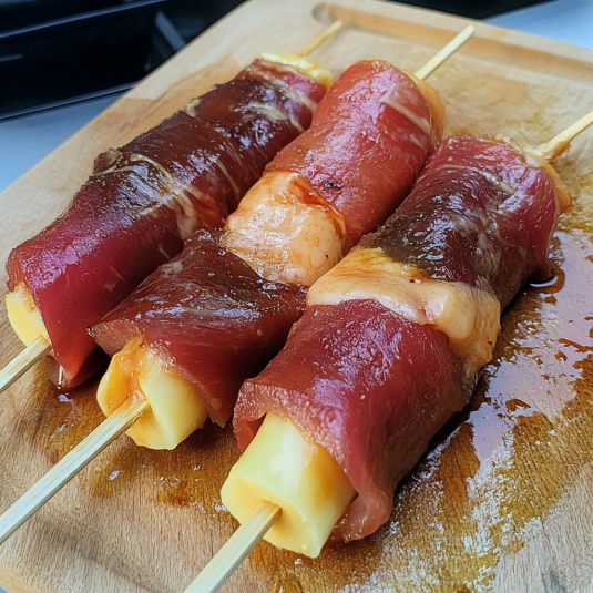 Préparation de brochettes boeuf fromage crues avec fromage en bâtonnet enroulé dans du carpaccio