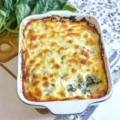 Plat de gratin de blettes à la béchamel doré au four, servi dans un plat blanc avec une garniture de fromage gratiné et des blettes fondantes.