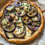 Tarte aux aubergines maison garnie de mozzarella fondante, aubergines rôties, ail grillé et herbes fraîches sur une pâte feuilletée dorée.