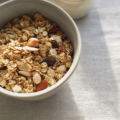 Bol de granola maison croustillant avec flocons d'avoine, amandes, noisettes et raisins secs.